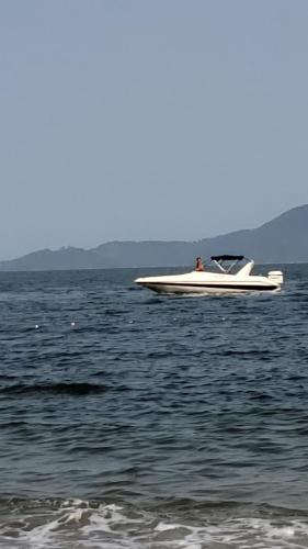 a white boat in the middle of the water at Aldeia dos reis - Condado - Mangaratiba - Loft 405 bl 3 in Mangaratiba
