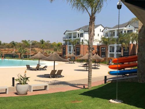 a resort with a pool with chairs and umbrellas at The Blyde Riverwalk Estate in Pretoria