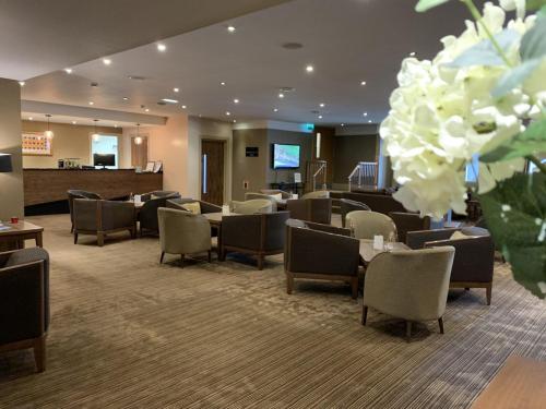 a hotel lobby with chairs and tables and flowers at Park Hotel in Falkirk