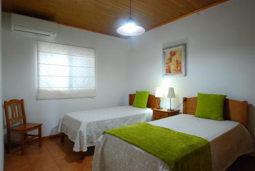 Faja GrandeにあるAlojamentos Flores Islandのベッド2台と窓が備わる客室です。