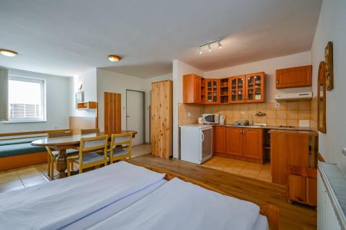 ein Zimmer mit einem Bett und eine Küche mit einem Tisch in der Unterkunft Relax Jasna in Liptovský Mikuláš