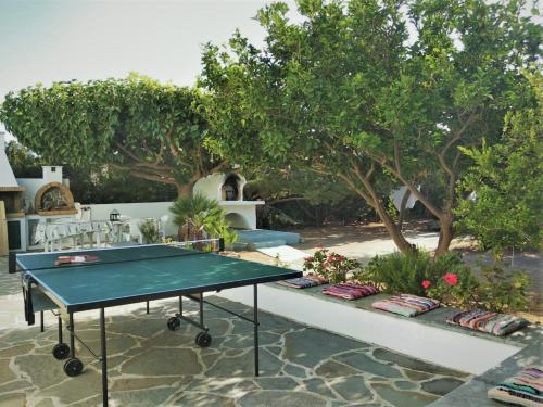 a ping pong table in a courtyard with trees at Villa Akti in Lachania