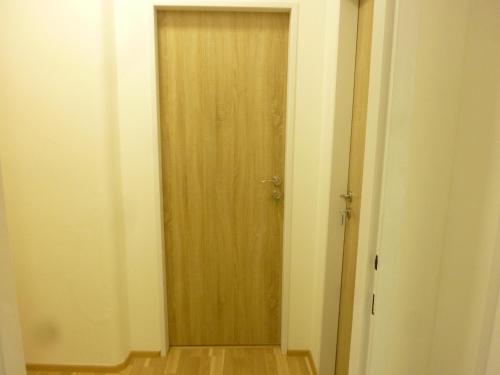 einen Flur mit Holztür in einem Zimmer in der Unterkunft Apartmán VAN NG in Prag