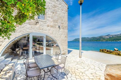 a patio with a table and chairs next to the water at Villa Gabriela in Korčula