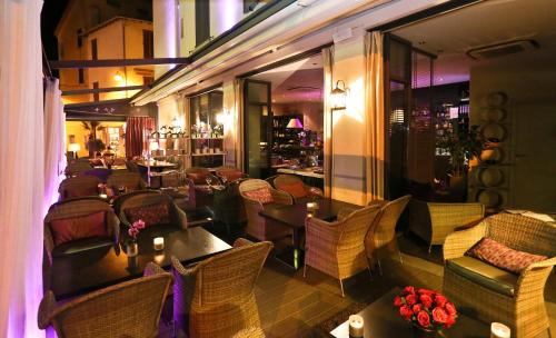 a restaurant with tables and chairs and a bar at La Place Boutique Hotel in Antibes