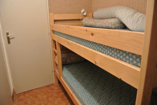 Zimmer mit einem Etagenbett und einer Holzleiter in der Unterkunft STUDIO in Thollon