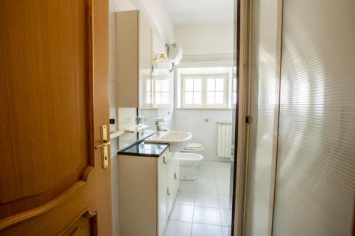 a white bathroom with a sink and a toilet at Valle Fiorita in Castro dei Volsci