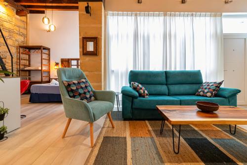 ein Wohnzimmer mit einem Sofa und einem Tisch in der Unterkunft Loft en casco histórico La Pintora - Parking publico opcional in Jerez de la Frontera