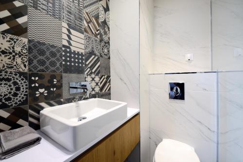 uma casa de banho com um lavatório branco e um WC. em Lou Cassiden - Magnifique appartement sur le Port em Cassis