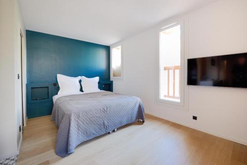um quarto com uma cama com uma parede azul em Lou Cassiden - Magnifique appartement sur le Port em Cassis