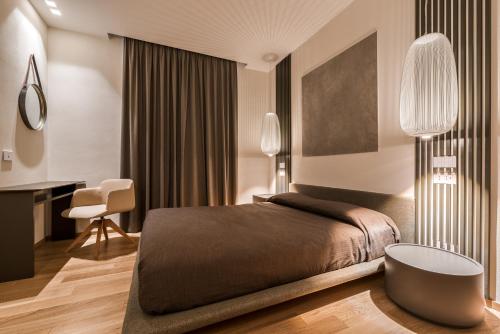 a bedroom with a bed and a desk and a chair at Resort Miramonti in Forte dei Marmi