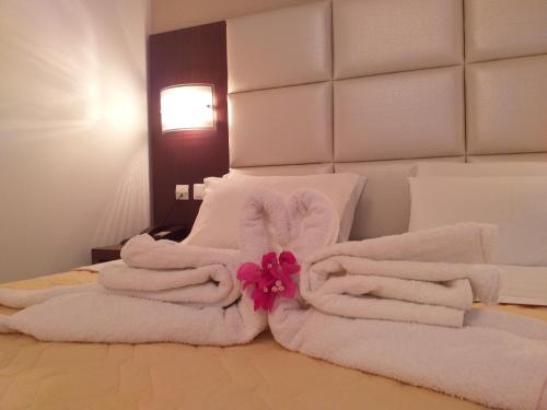 a pile of towels sitting on top of a bed at Castelia Bay Hotel in Amoopi