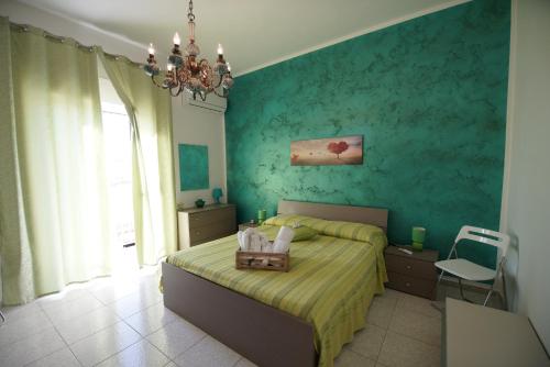 um quarto com uma cama e uma parede verde em B&B Nodo Francescano em Porto Empedocle