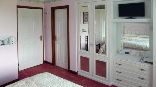 a room with a bedroom with a bed and a tv at The Sheiling in Laide