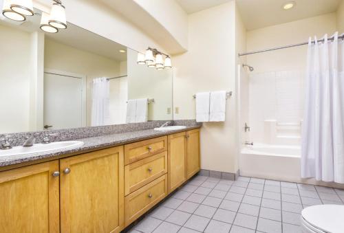 a bathroom with two sinks and a tub and a toilet at WorldMark Cathedral City in Cathedral City