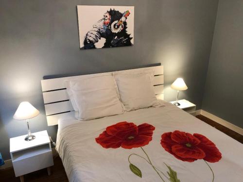 a bedroom with a bed with two red flowers on it at Le Sainte Marie in Compiègne