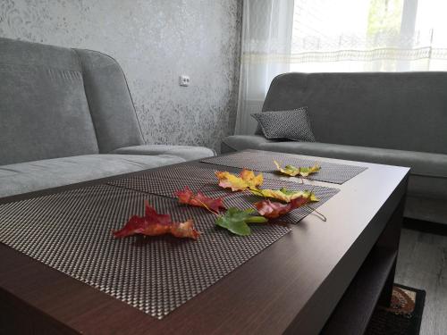 stolik kawowy z jesiennymi liśćmi na górze w obiekcie Apartamentai ,,ASTRA'' w mieście Birsztany