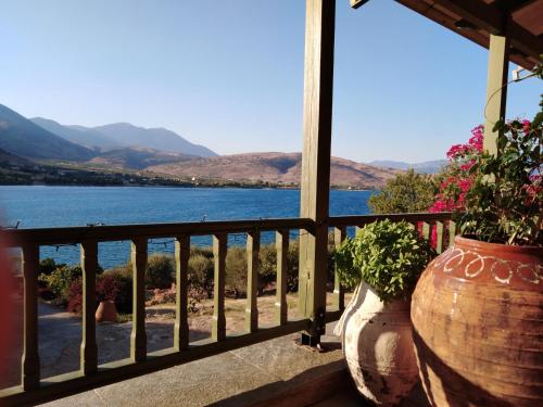 a balcony with two large vases with flowers on it at Aphrodite's Coast Retreat House! in Galaxidhion