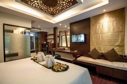 a hotel room with a bed with towels on it at Peach Hill Resort - SHA Extra Plus in Kata Beach