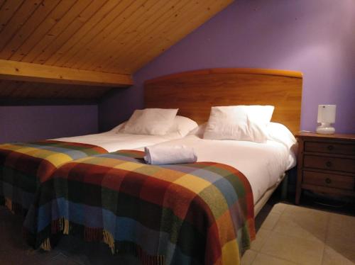 um quarto com 2 camas e uma cabeceira em madeira em CASA DE CIMADEVILA em Santiso