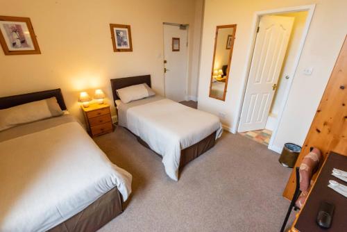 a bedroom with two beds and a mirror at Aarondale Guest House in Hartlepool