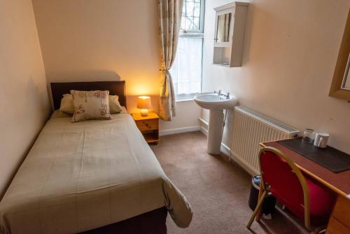 ein kleines Schlafzimmer mit einem Bett und einem Waschbecken in der Unterkunft Aarondale Guest House in Hartlepool
