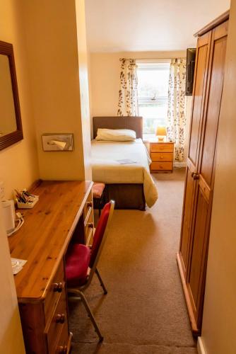 a bedroom with a bed and a desk with a desk at Aarondale Guest House in Hartlepool