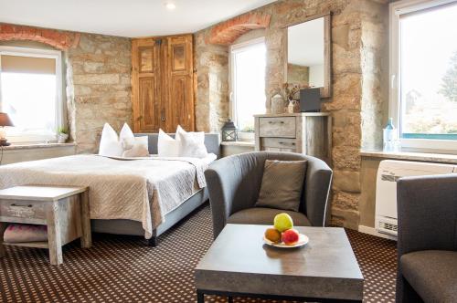ein Hotelzimmer mit einem Bett und zwei Stühlen in der Unterkunft "Alte Pension" Bautzen in Bautzen
