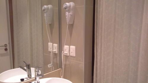 a bathroom with a sink and a shower with a phone at Green Park Apartamento con Balcón vista Lago in Punta del Este