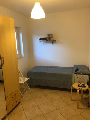 a small bedroom with a bed and a chair at GIGLIO DI MARE Residence in Sellia Marina