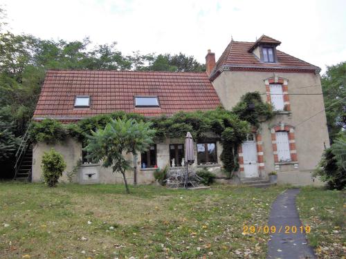 an old house with a tree in front of it at Maison du Moulin Galuzot in Saint-Vallier
