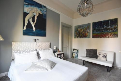 a bedroom with a white bed and a chair at A Casa dell'Artista ViKi in Iesi