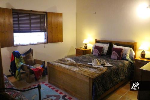 a bedroom with a bed and a chair and a window at Quinta do Paraíso in Porto Martins