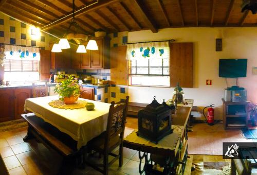 a kitchen with a table and chairs in a room at Quinta do Paraíso in Porto Martins