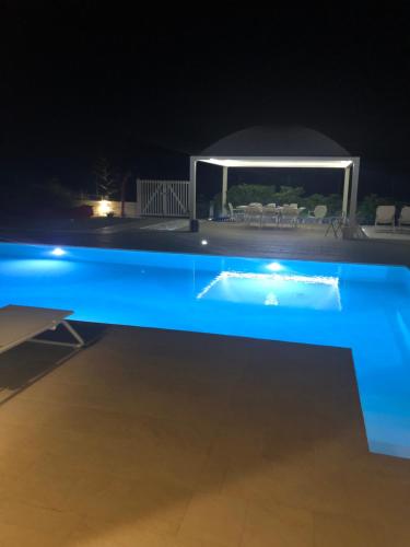 a swimming pool lit up at night at GIGLIO DI MARE Residence in Sellia Marina