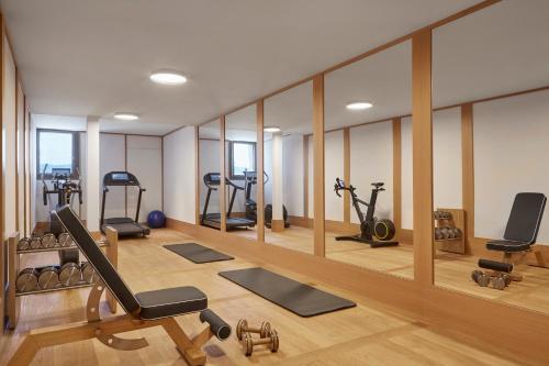 a gym with several treadmills and elliptical machines at Alex Lake Zürich in Thalwil
