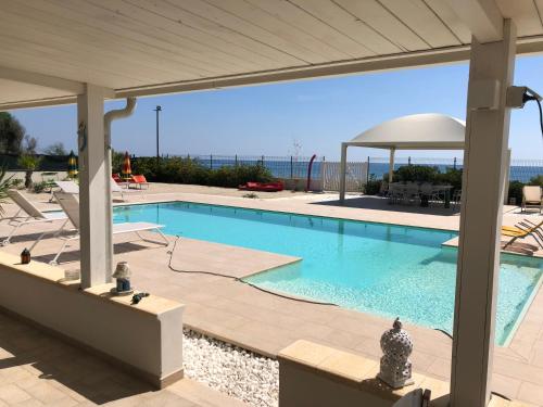 a large swimming pool with a pavilion next to at GIGLIO DI MARE Residence in Sellia Marina