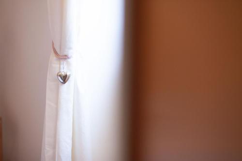 a white shower curtain with a heart hanging from it at Valle Fiorita in Castro dei Volsci