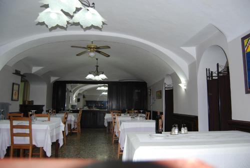 un ristorante con tavoli e sedie bianchi e un ventilatore a soffitto di Albergo della Posta a Trivero