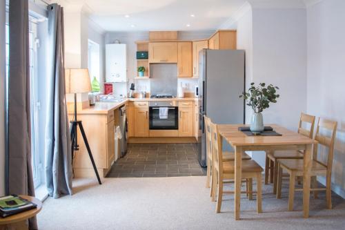 a kitchen with a table and a refrigerator at Appleby Darlington in Darlington