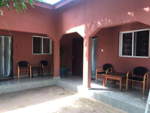 a room with chairs and a table in a house at The Gunjur Project Lodge in Gunjur