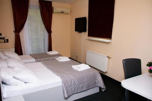 a hotel room with two beds and a desk at Kizhi ART Hotel Kharkiv in Kharkiv
