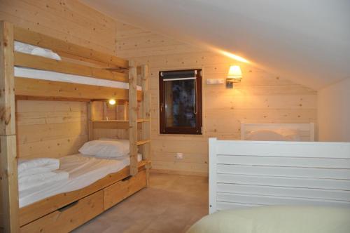 ヴァールにあるChalet L'Establouの木造キャビン内のベッドルーム1室(二段ベッド2組付)