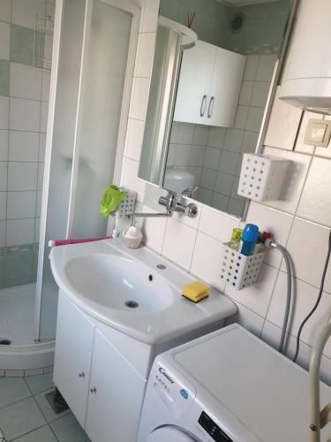 a white bathroom with a sink and a mirror at Terme Čatež Apartma Nine in Čatež ob Savi
