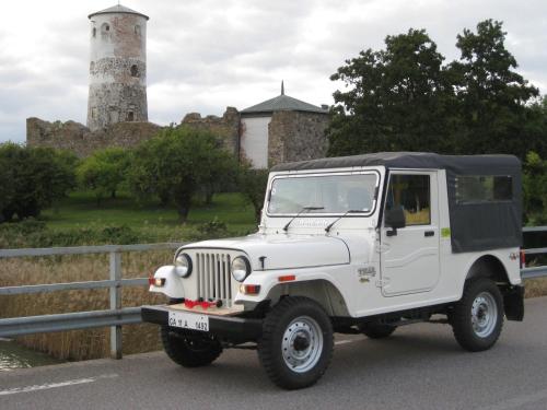 a white jeep driving down a road with a lighthouse at Stenslid Bottna By St Anna in Söderköping