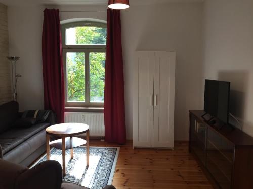 - un salon avec un canapé et une fenêtre dans l'établissement Ferienwohnung Huttenstraße Halle, à Halle-sur-Saale