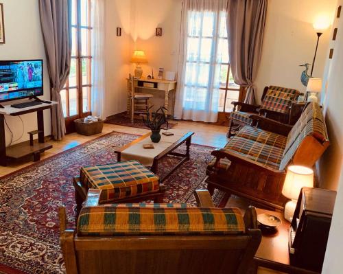 Il comprend un salon doté de meubles et d'une télévision à écran plat. dans l'établissement Vravrona Family House, à Artemi