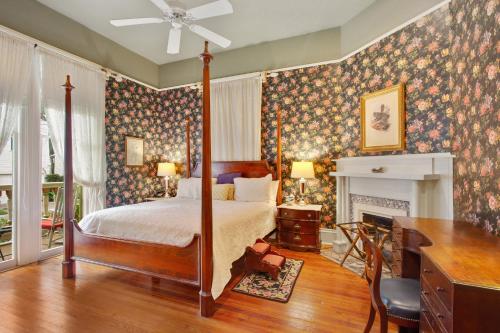 a bedroom with a canopy bed and a fireplace at Maison Perrier Bed & Breakfast in New Orleans
