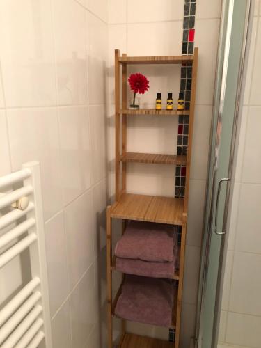 a bathroom with a wooden shelf with three towels at Le Paillot de Montabert Hyper Centre classé in Troyes