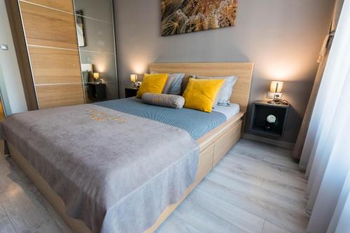 a small bedroom with a bed with yellow pillows at Kapana Luxury City Center Apartments with Garage in Plovdiv